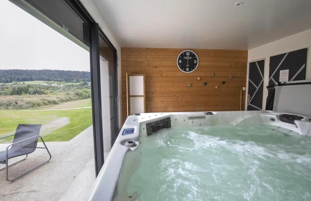 ein Whirlpool in einem Zimmer mit einer Uhr in der Unterkunft L'esca'lac in Grande Riviere
