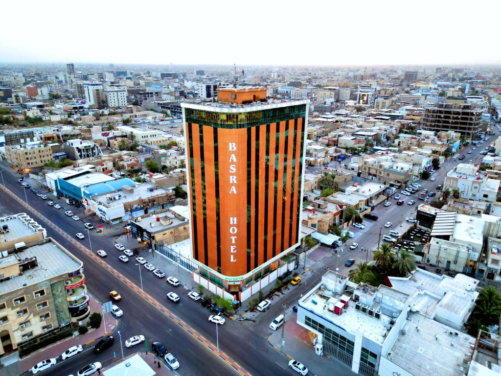 a tall building in the middle of a city at Basra Touristic Hotel in Al Başrah