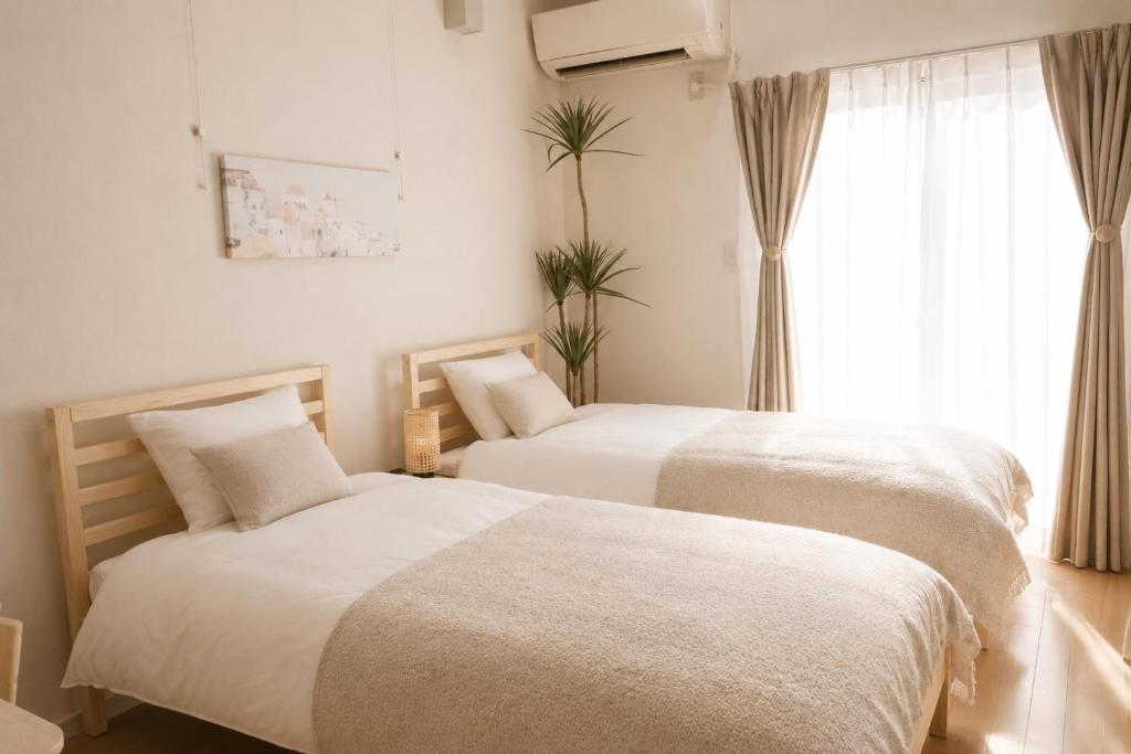 two beds in a room with a window at Dori Dori House Ebisu in Tokyo