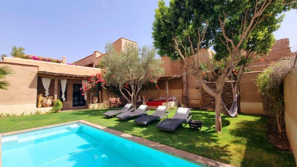 a backyard with a swimming pool and a house at Tagadert Lodge in Oumnas