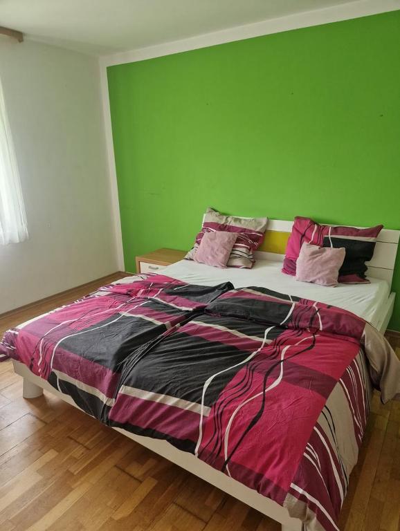a bedroom with a large bed with a green wall at Schönes Doppelzimmer in Allmannshofen
