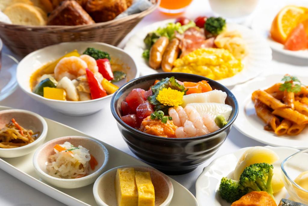 a table topped with bowls of different types of food at Kushiro Prince Hotel in Kushiro