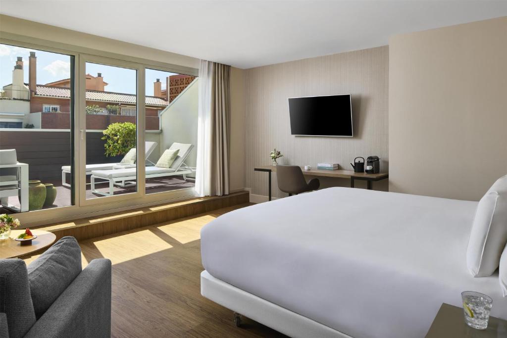a hotel room with a bed and a living room at NH Sants Barcelona in Barcelona