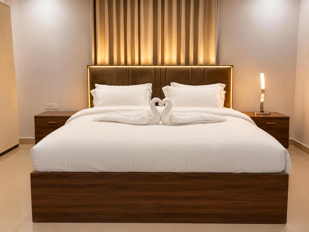two swans sitting on top of a bed at Albazar Residence Salalah in Salalah