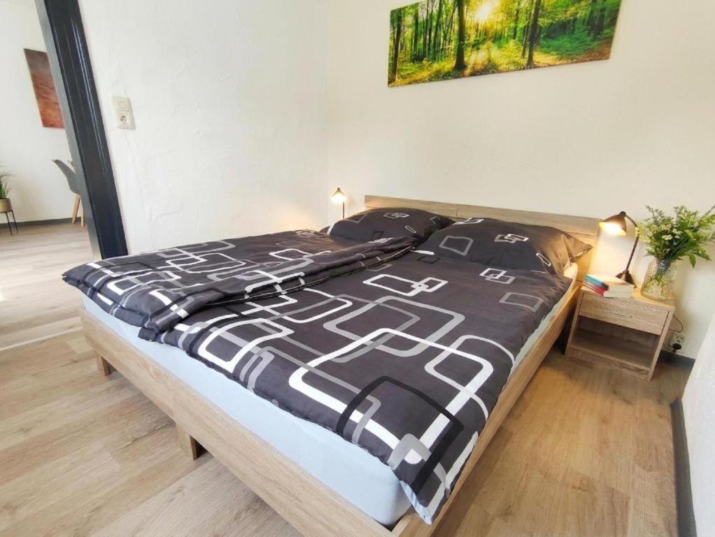 a bed with a black and white blanket on it at Pension am Kirchberg - Zimmer 2 in Daun