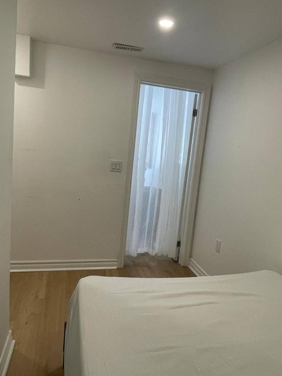 an empty room with a bed and a window at Oshawa Suite Open Kitchen Living Space in Oshawa