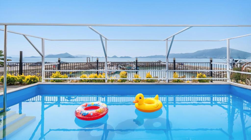 two inflatable rubber ducks in a swimming pool at Yeosu Wayo Ocean View Pension in Yeosu