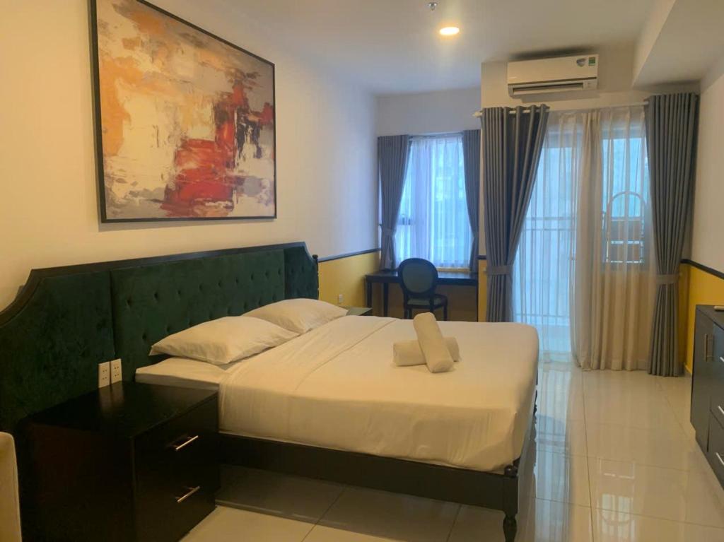 a bedroom with a bed in a room with windows at NAYO Cam Ranh - Beachfront Residence in Cam Ranh International Airport