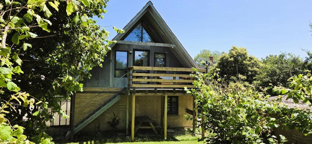 a tree house with a deck and a porch at Fuglsang Langeland in Tranekær
