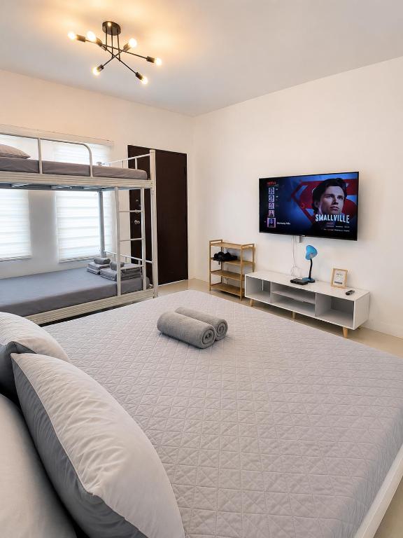 ein Schlafzimmer mit einem großen Bett und einem Flachbildfernseher in der Unterkunft Harmony Villa in Tanza