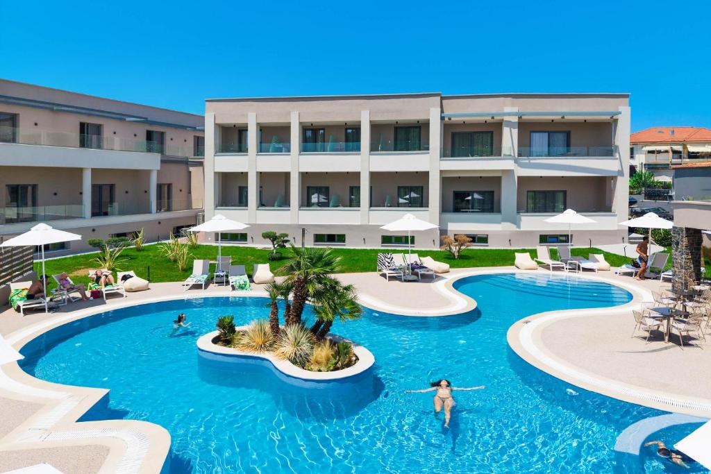 a pool at a resort with people swimming in it at Anẽse Vacation Feelings in Paliouri