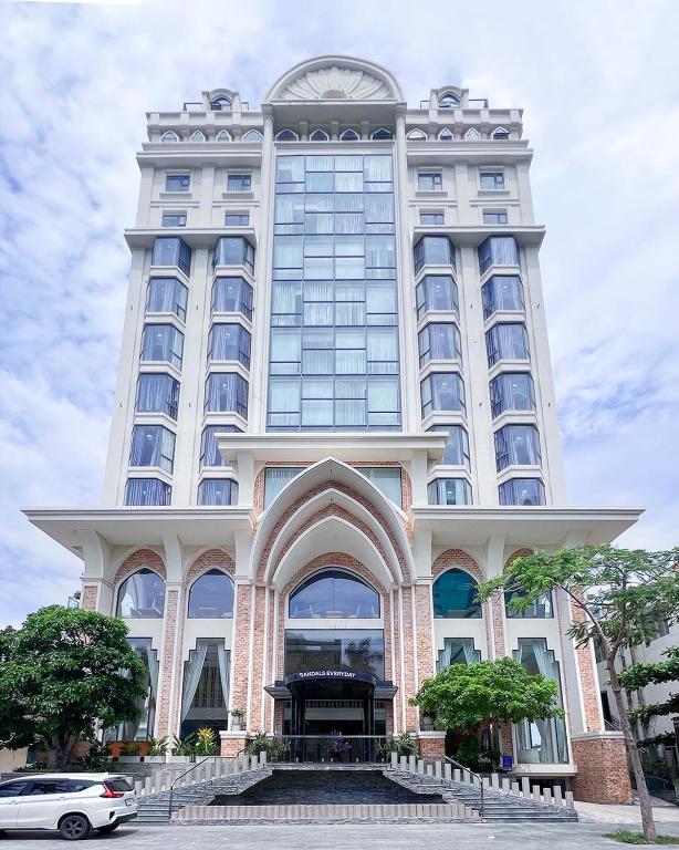 a large white building with a clock on it at Sandals Everyday Hotel in Tuy Hoa