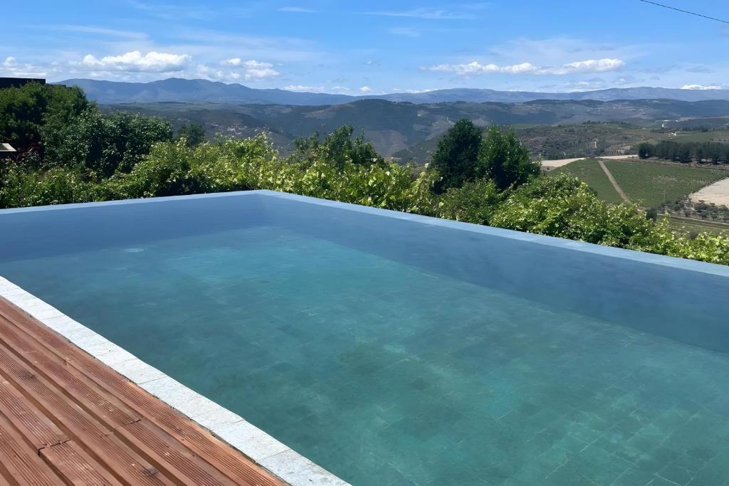 a swimming pool with a view of the mountains at Douro Barcos House Local in Barcos