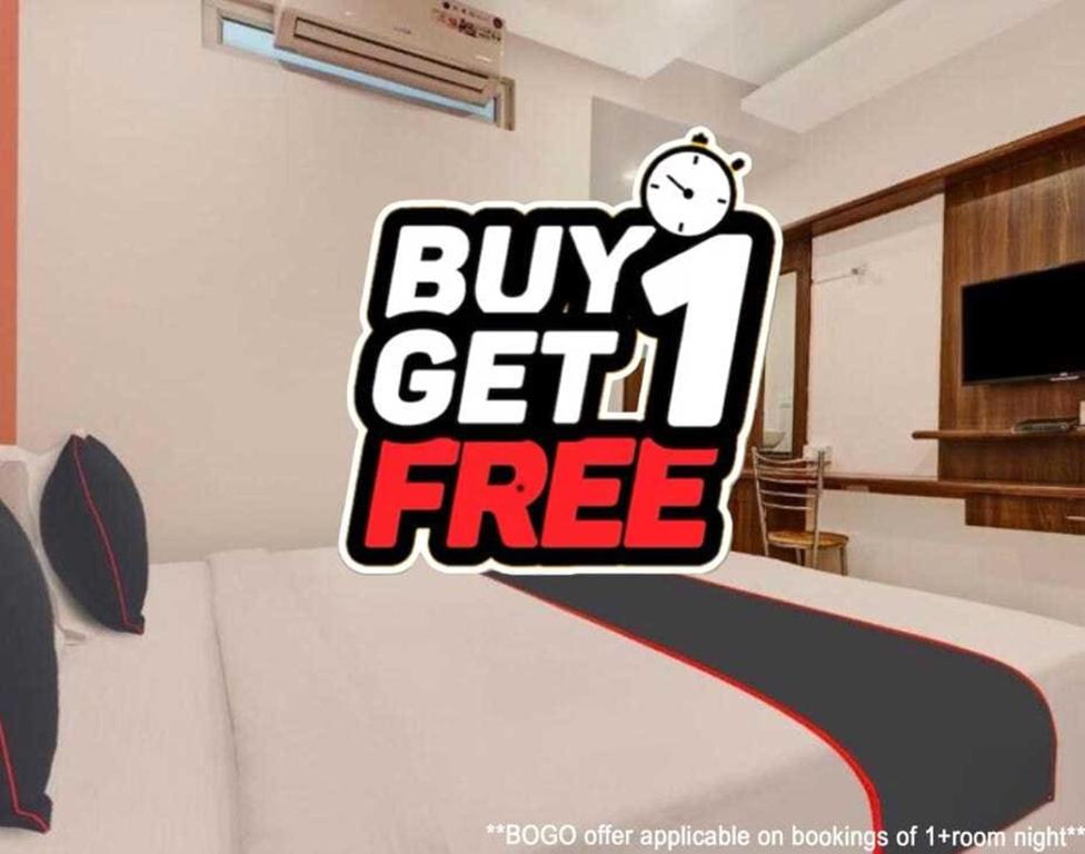 a bed with a buy get free sign on it at Super Hotel O Temple Road Vemulavada in Karīmnagar