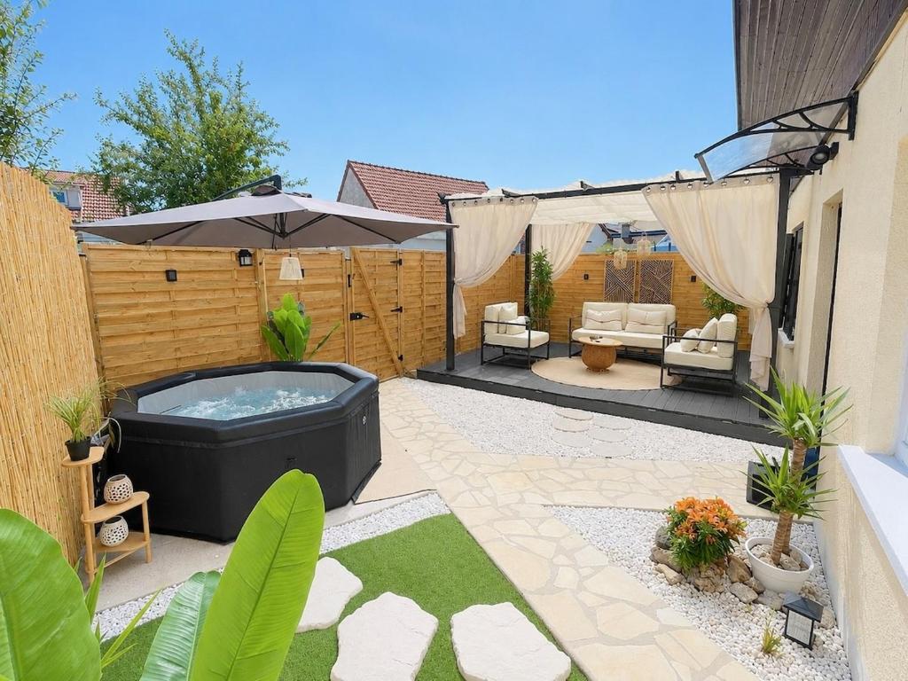 a patio with a hot tub in a yard at Sweet Escape et Jacuzzi Privé in Gonesse