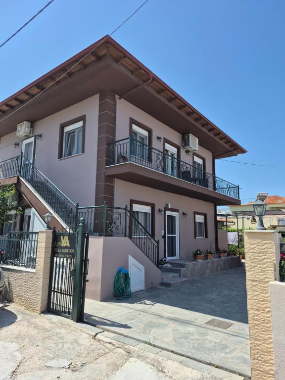 a house with a balcony and a gate at Villa Aggelos in Skala Sotiros