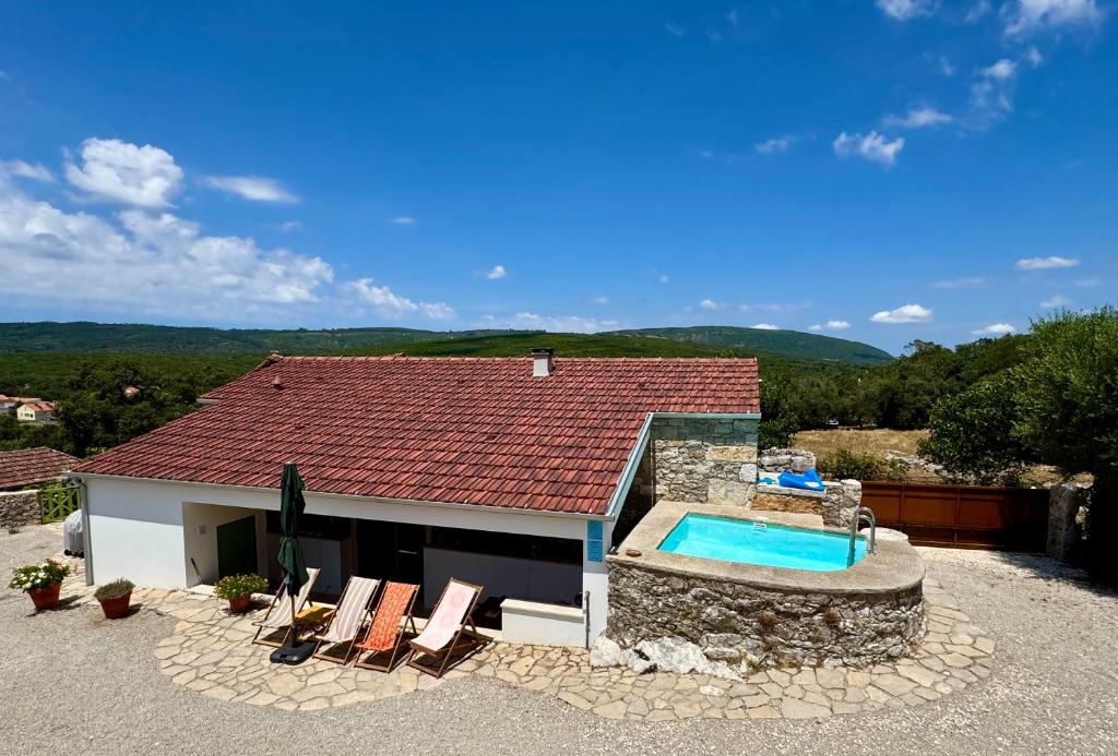 a house with a swimming pool and some chairs at Casa da Curva in Mendiga
