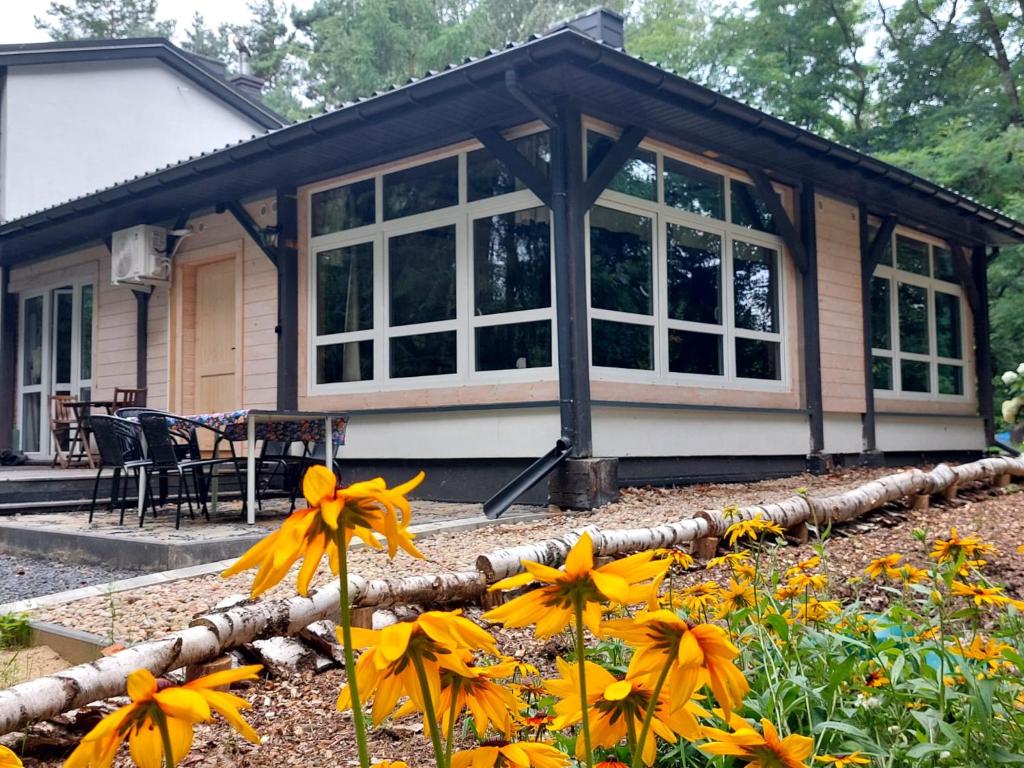 a house with windows and flowers in front of it at Apartament WERANDA in Paplin