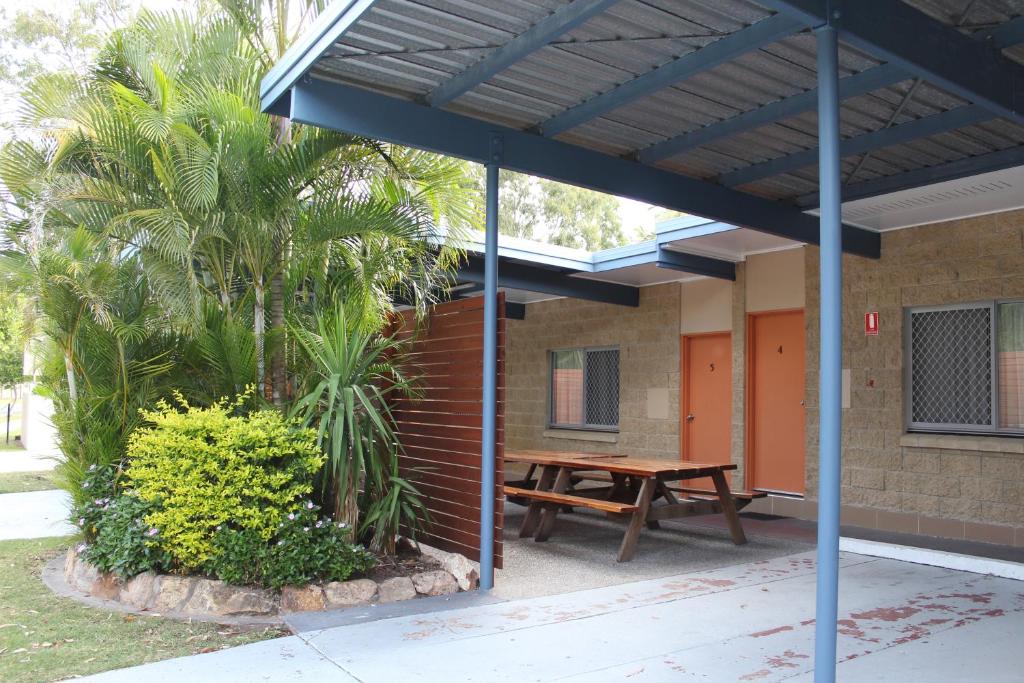 un patio con una mesa de madera y una mesa de picnic en Mango Tree Motel, en Agnes Water