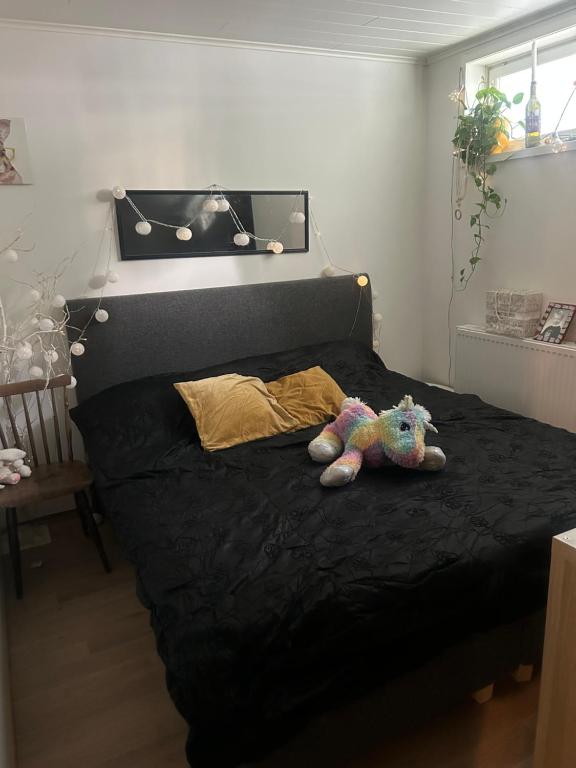 a teddy bear laying on a bed in a bedroom at Kolmio lähellä palveluita in Tampere