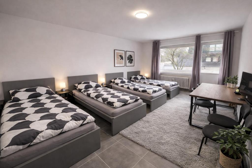 a bedroom with four beds and a desk and a table at Pulheim Living 4 in Pulheim