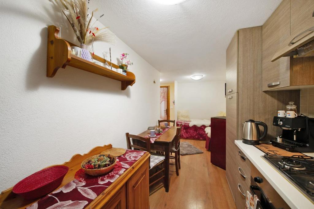 a kitchen with a table and a dining room at L'archetto Valle d'Aosta in La Salle