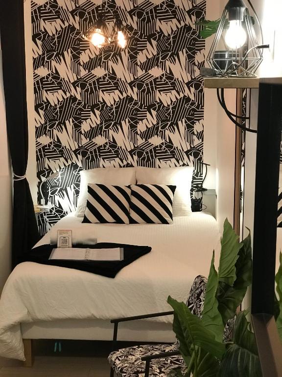 a bedroom with a bed with a black and white wallpaper at La Joueuse, Et pop Et Chic ! in Poitiers