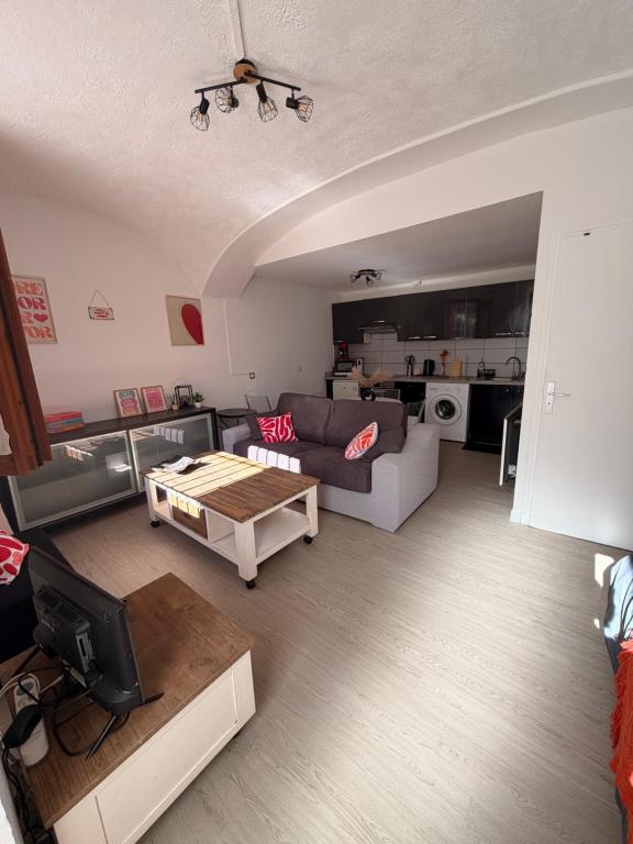 a living room with a couch and a table at Studio centre du village in Tende