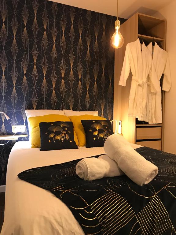 a bedroom with a bed with a robe hanging on a wall at La Céleste, Et Pop Et Chic ! in Poitiers