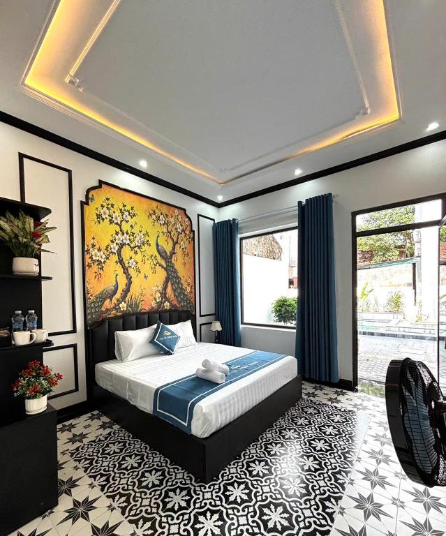 a bedroom with a bed with a large painting on the wall at Tam Coc Sunny House in Vũ Lâm