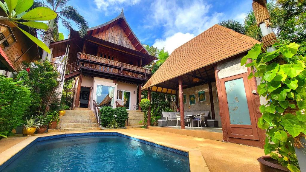 a house with a swimming pool in front of a house at Villa Ayutthaya, Private Pool Near Kantiang Beach in Ko Lanta
