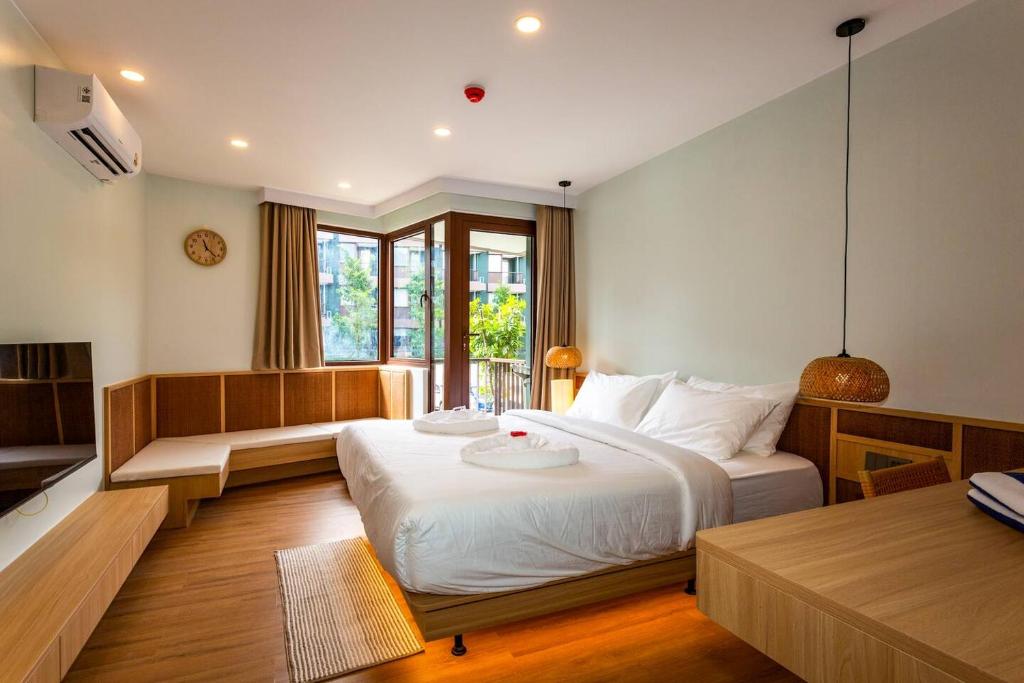 a bedroom with a large white bed and a window at Wing 4203 - Modern Resort Studio Koh Samui in Bophut