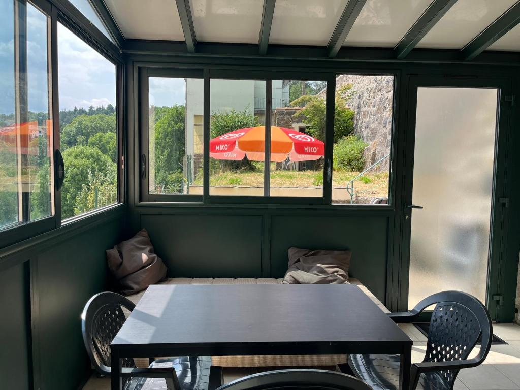 a table and chairs in a room with a window at Appartement le Gallon in Langogne