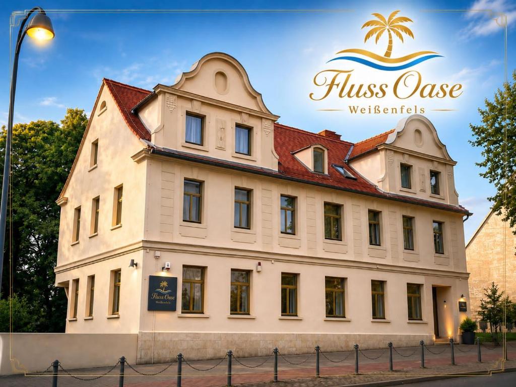 a building with a sign on the side of it at Hotel Fluss Oase - Feldschlößchen in Weißenfels