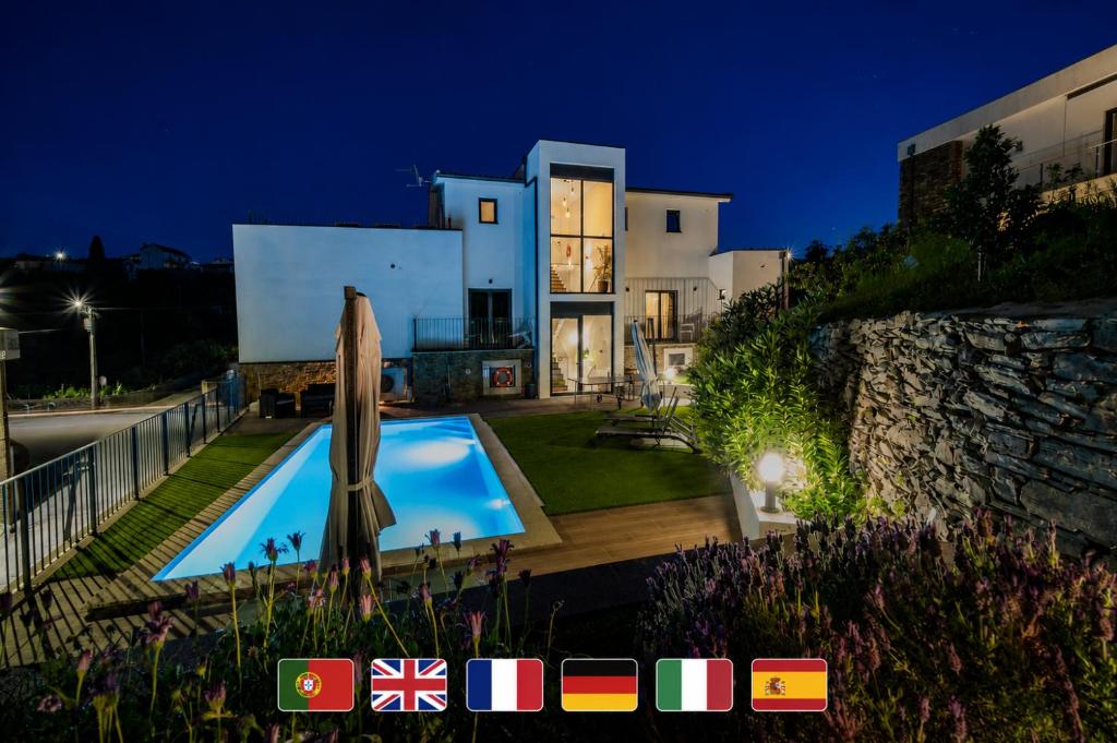 a villa with a swimming pool at night at Casa Dona Edite Guesthouse Douro in Vilarinho de Cotas