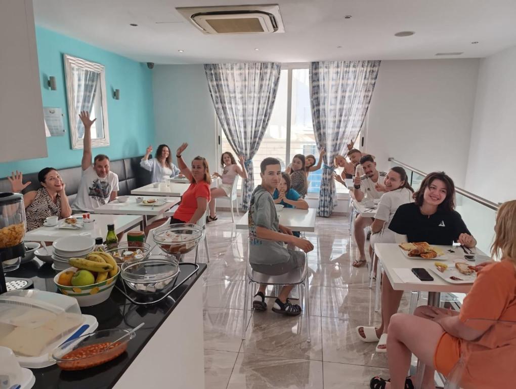 a group of people sitting at tables in a room at Harbour Lodge in Marsaxlokk