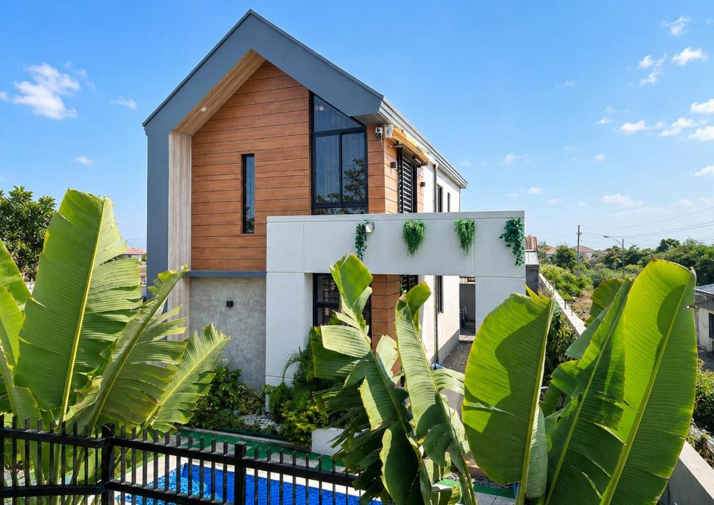 a wooden house with a black fence at Sharma Nosso Canto in Arayat