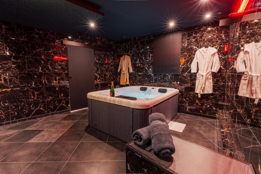 a bathroom with a jacuzzi tub in a room at L'inavouable Love-room Jacuzzi in Marquise