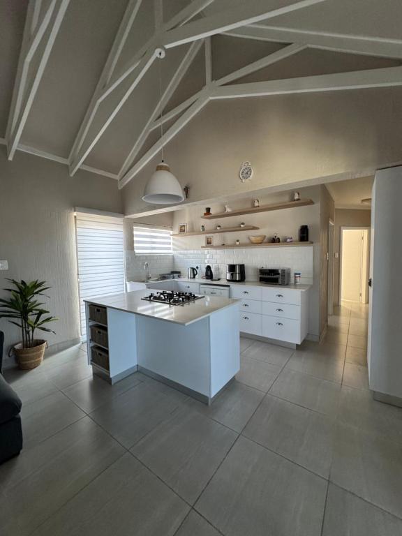 a large kitchen with a white island in a room at Oceanview Stays in Great Brak River