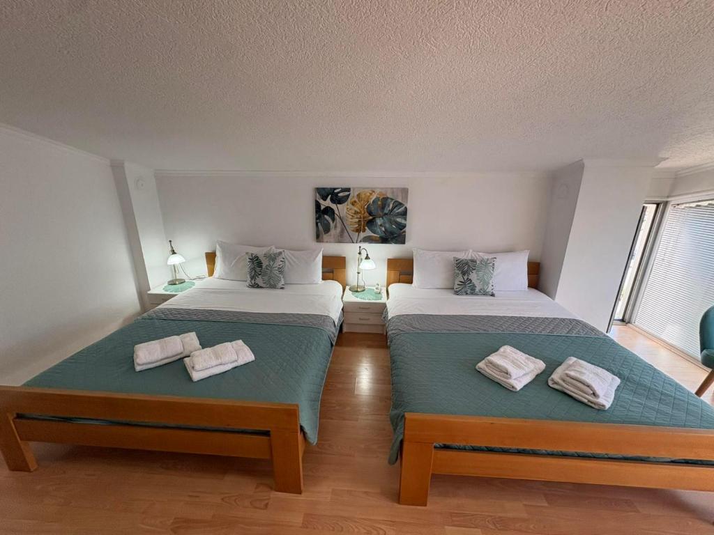 a bedroom with two beds with towels on them at SIENA Apartment in Gevgelija