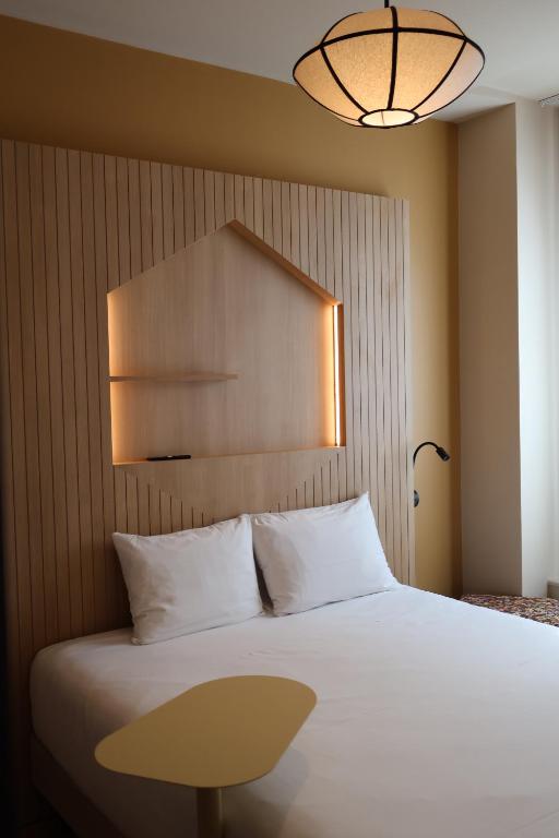 ein Schlafzimmer mit einem großen weißen Bett und einer Lampe in der Unterkunft Best Western Lyon Saint-Antoine in Lyon