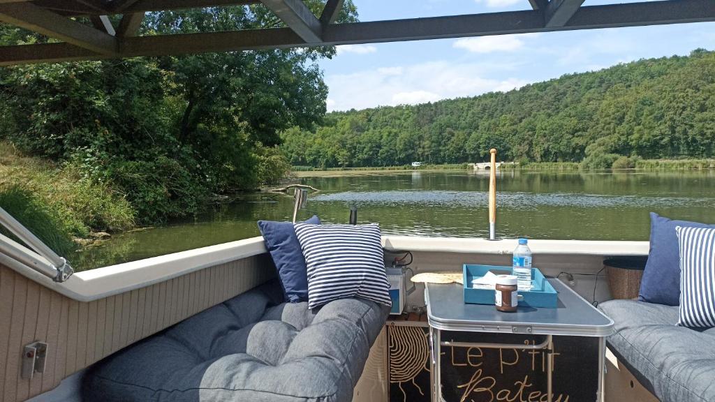 a boat with two couches and a table on the deck at Petit Shetland in Liverdun