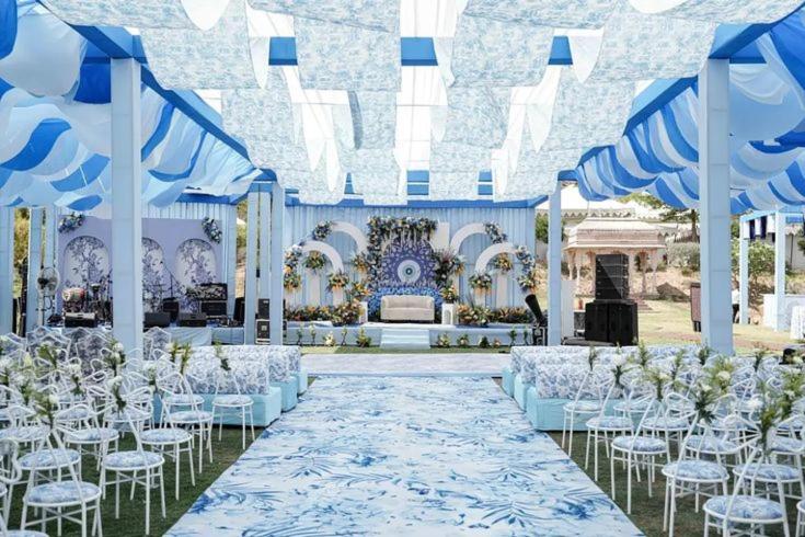 a blue and white wedding with white chairs and tables at dashupunit in Pushkar