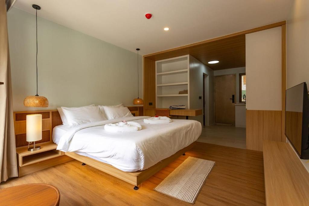 a bedroom with a large white bed with two towels at Wing 4206 - Modern Resort Studio Koh Samui in Bophut