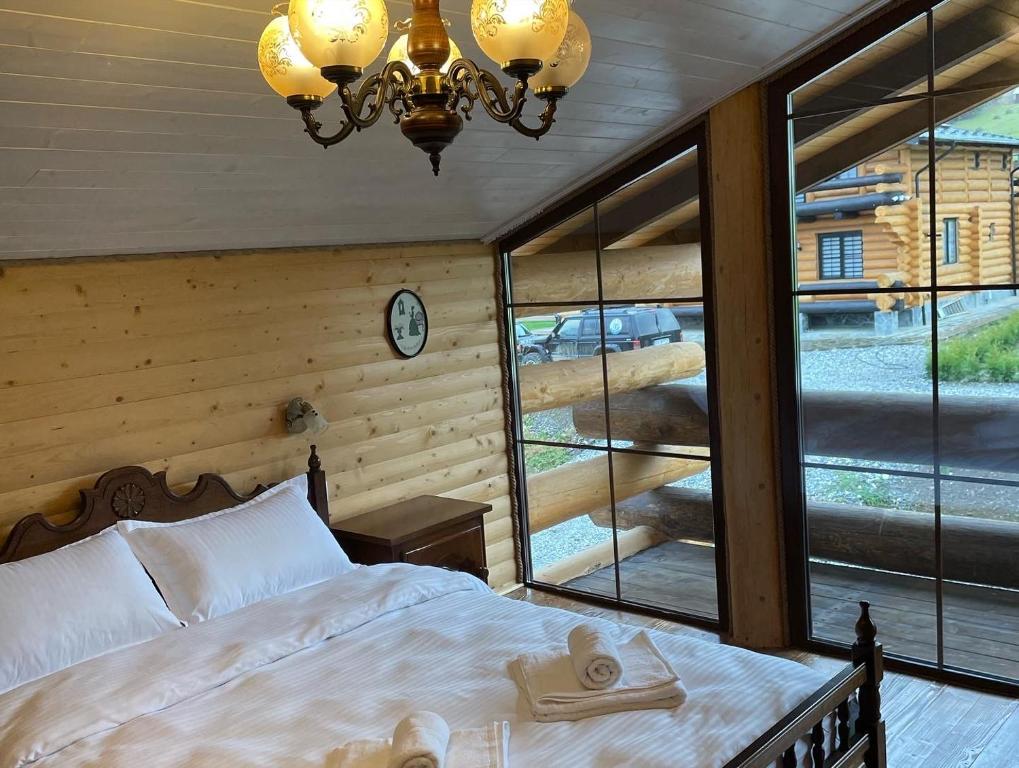a bedroom with a bed and a large window at Chalet Poligon in Vatra Dornei