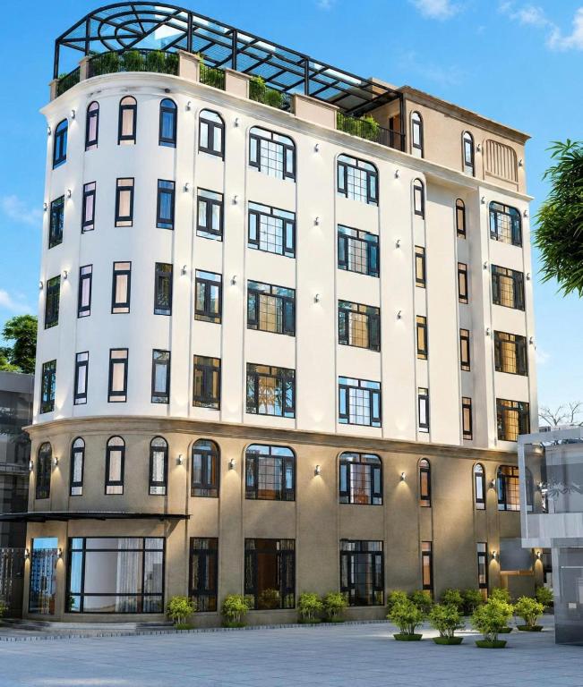 a large white building with a lot of windows at Nhật Lệ River Hotel Quảng Bình in Huân Cát