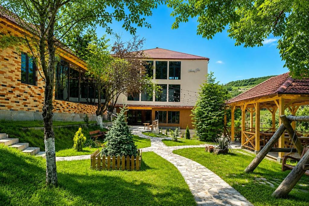 a garden in front of a building with a christmas tree at Madin Eco Hotel in Debed