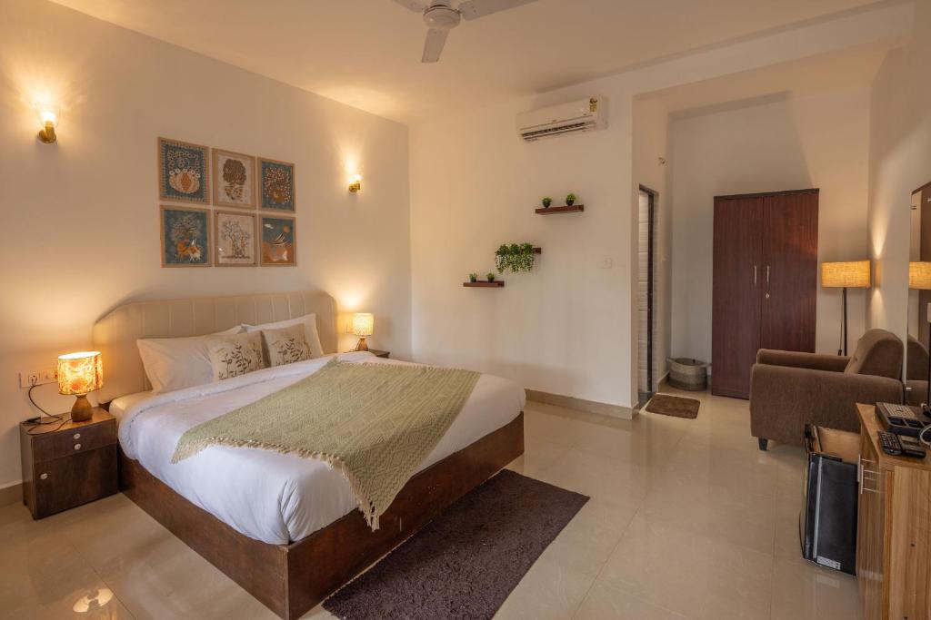 a bedroom with a bed and a living room at Palolem White House in Canacona