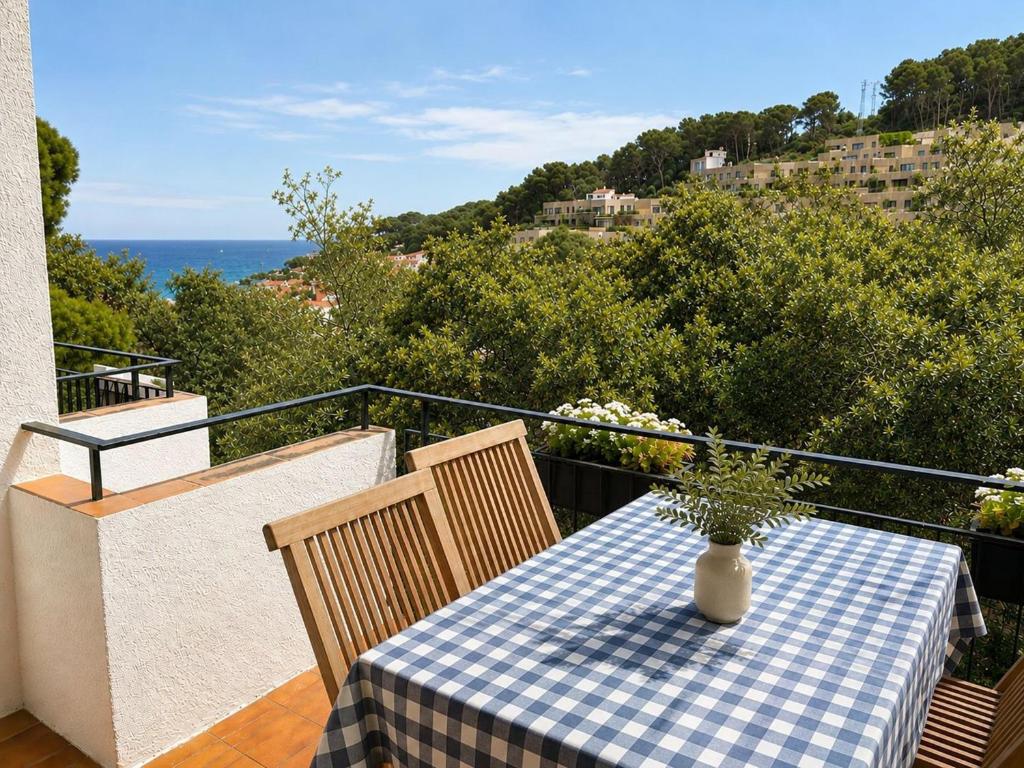 ein Tisch mit einer blau-weiß karierten Tischdecke auf einem Balkon in der Unterkunft Mas Mato, 25, 3B in Begur
