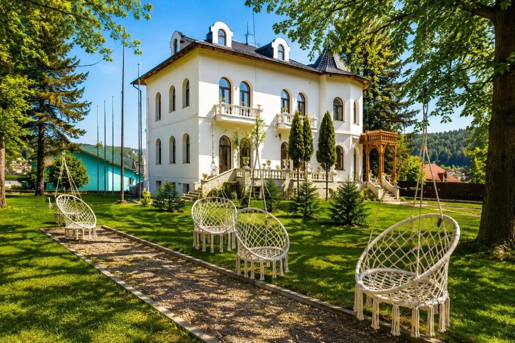 a group of chairs in front of a house at Queen's Crown Manor in Predeal